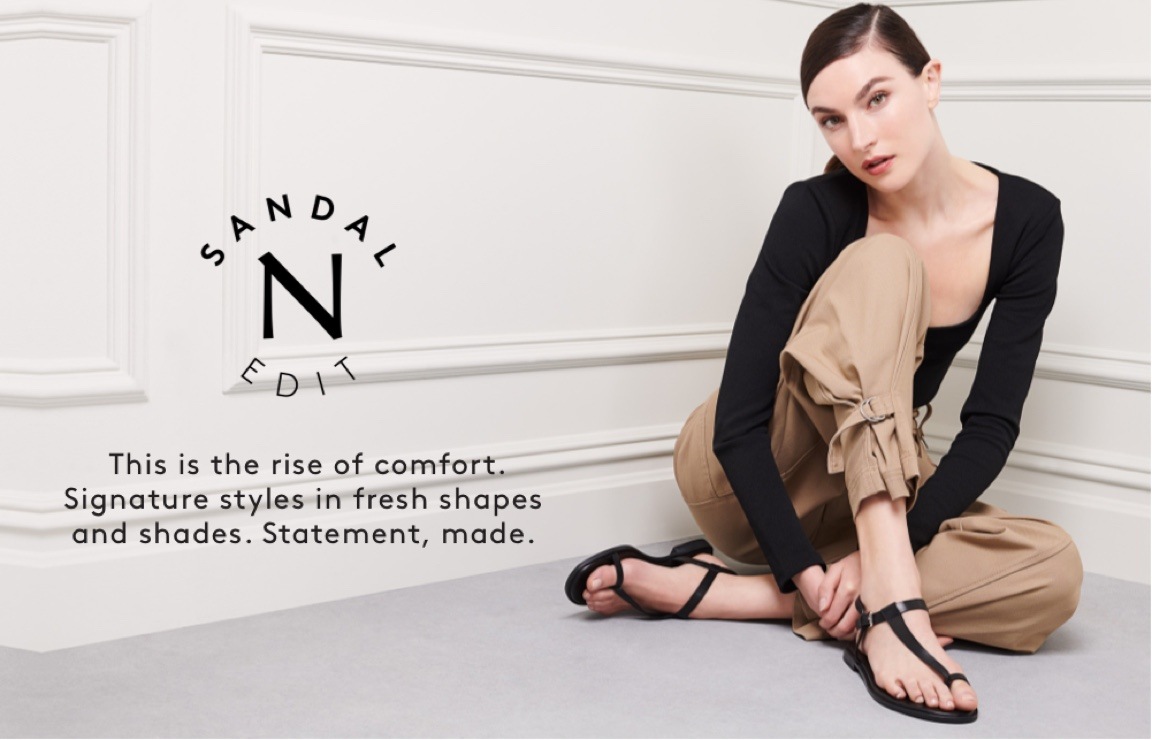 model sitting wearing the Naturalizer FIfi sandal in black